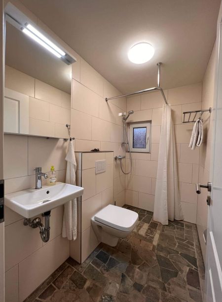 Das Badezimmer mit Natursteinboden